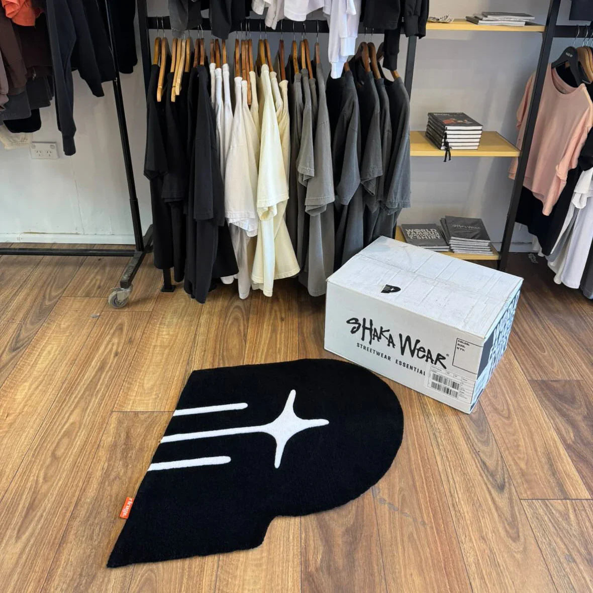 Handmade black tufted rug with white abstract design on wooden floor in clothing store