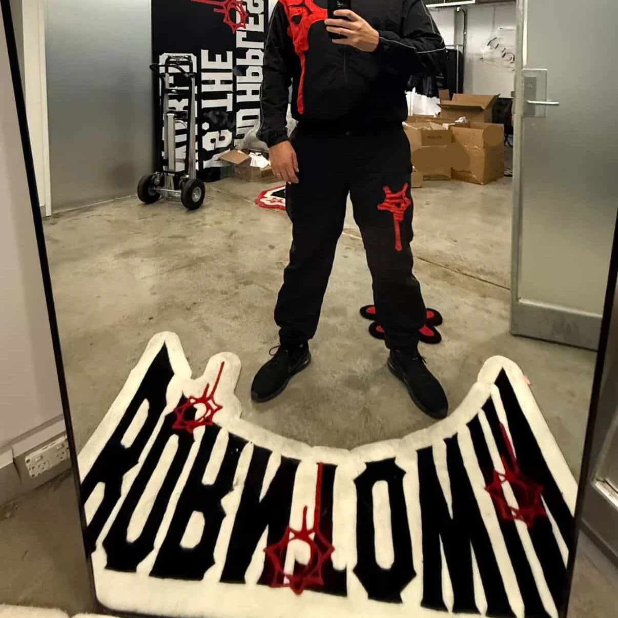 Handmade tufted custom rug with bold black and white lettering and red accents in modern room