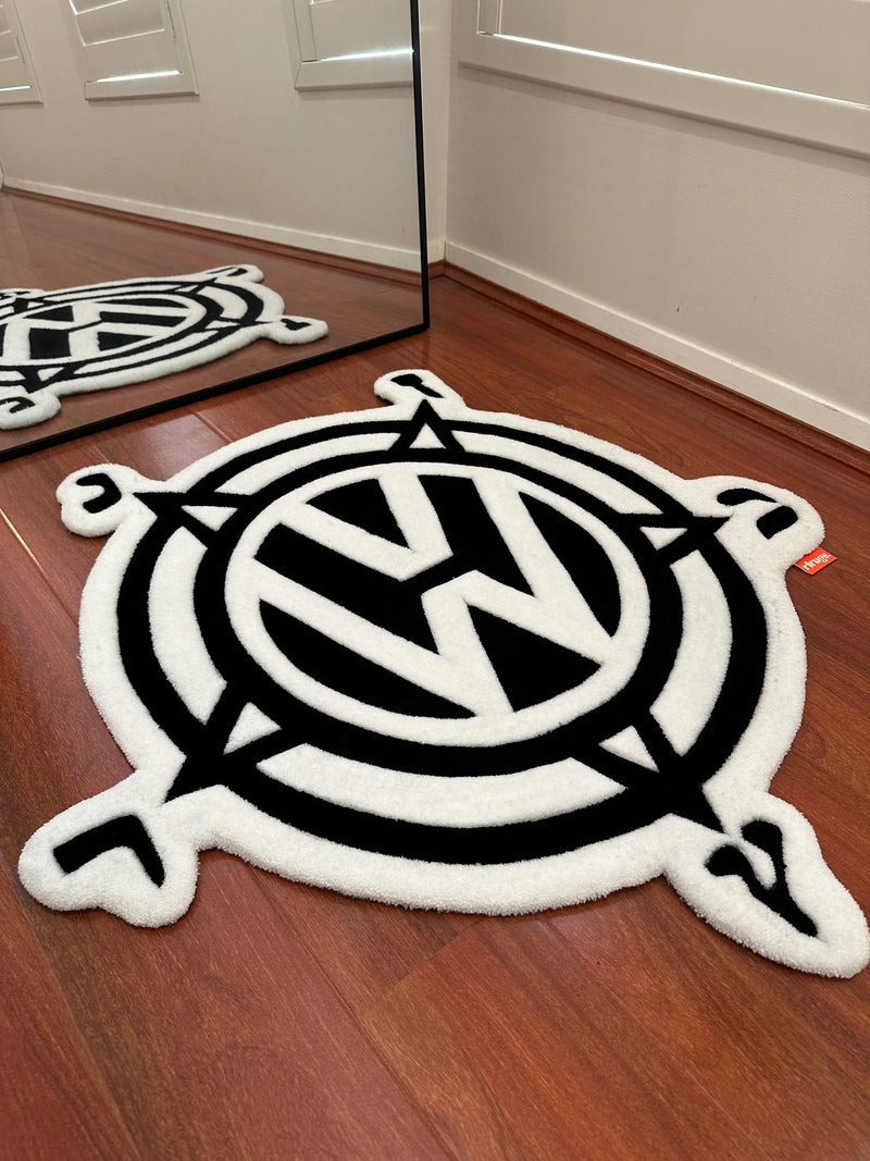 Handmade black and white tufted rug with geometric compass design on wooden floor
