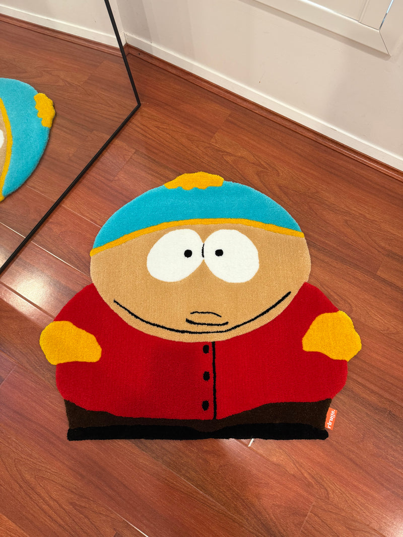 Handmade tufted rug shaped like a cartoon character with blue hat, red jacket, on wood floor