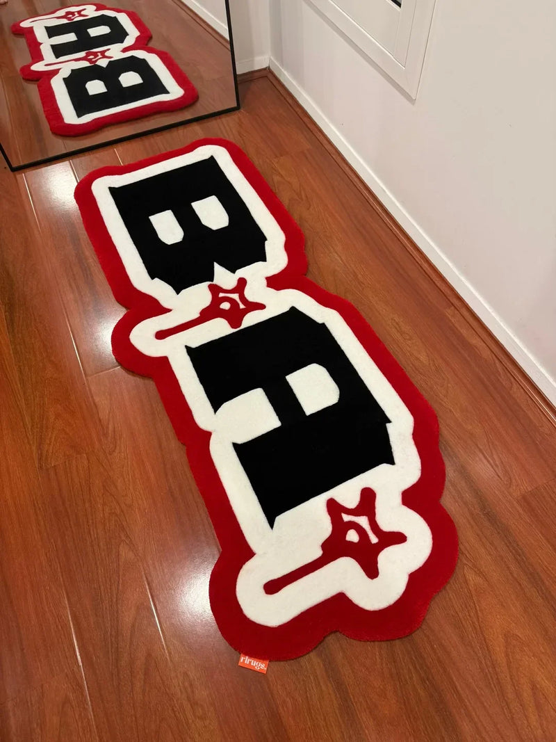 Handmade black, white, and red tufted rug with bold graphic design on wooden floor