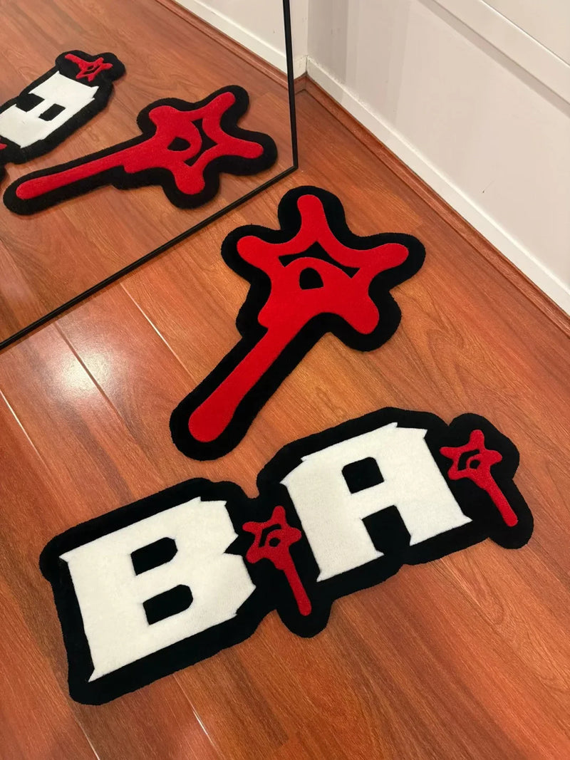 Custom handmade tufted rug with bold white letters and red abstract shapes on wood floor