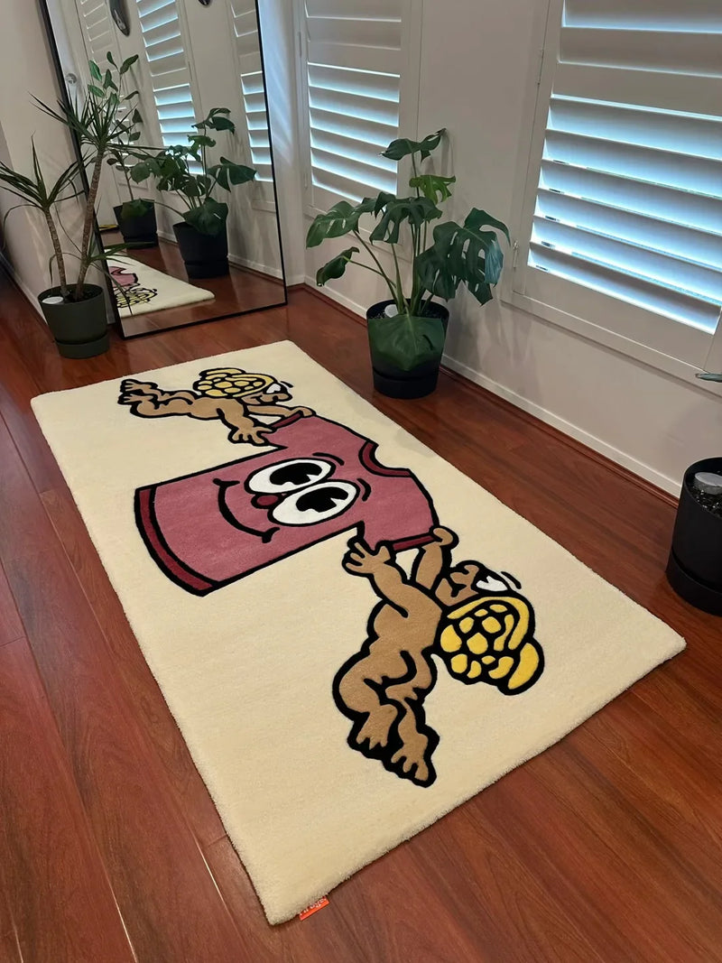 Handmade tufted rug with cartoon baby angel and pink book design on wooden floor, indoor plants nearby