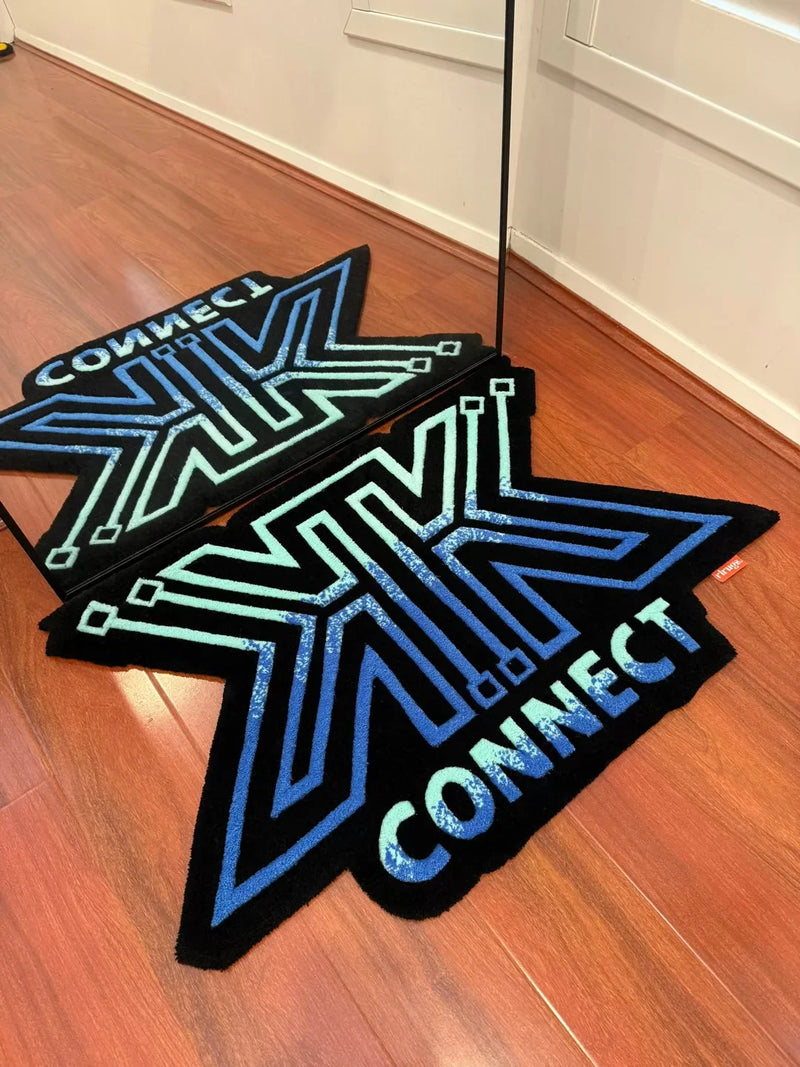 Handmade tufted rug with blue and green geometric 'CONNECT' design on wooden floor