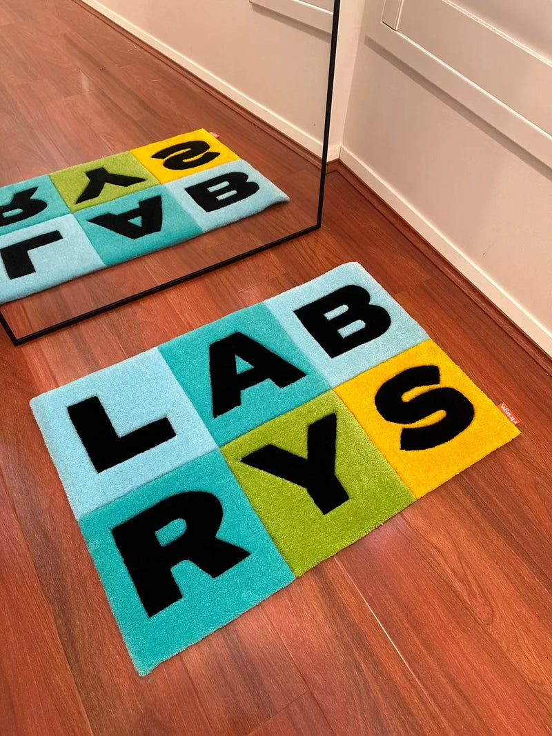 Handmade tufted rug with colorful LABRYS letter blocks on wooden floor, modern decor