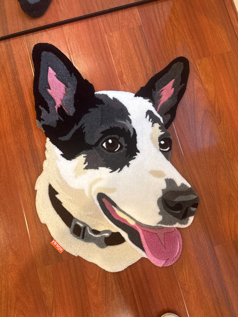 Handmade tufted rug of a black and white dog face with pink tongue on wood floor
