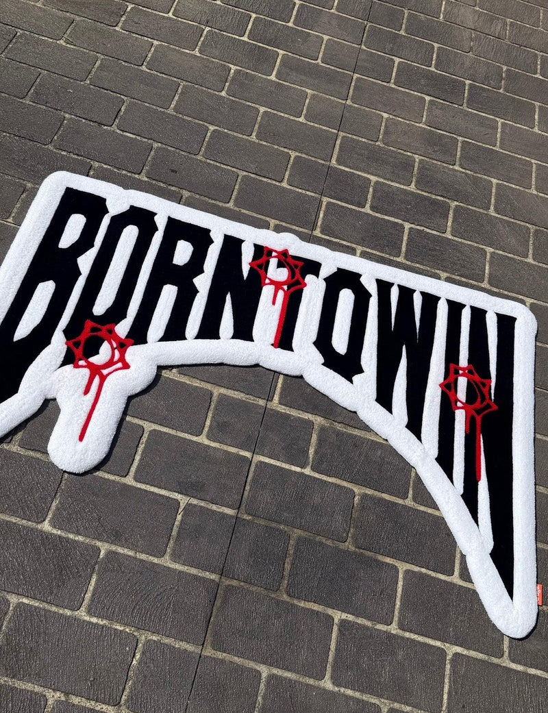 Custom handmade tufted rug with bold lettering and red graphic accents on pavement