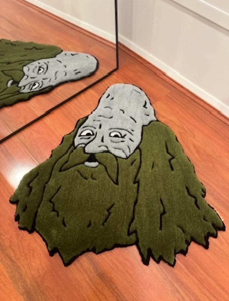 Handmade tufted rug with a cartoon bearded face design on wooden floor, reflected in mirror