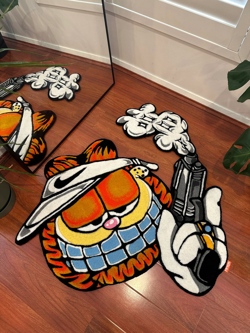 Handmade tufted cartoon rug with orange cat in hat, holding stylized object on wooden floor
