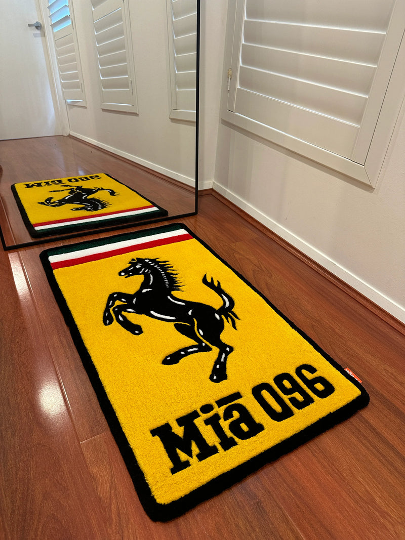 Handmade yellow tufted rug with black prancing horse, Italian flag stripes, and text, on wooden floor